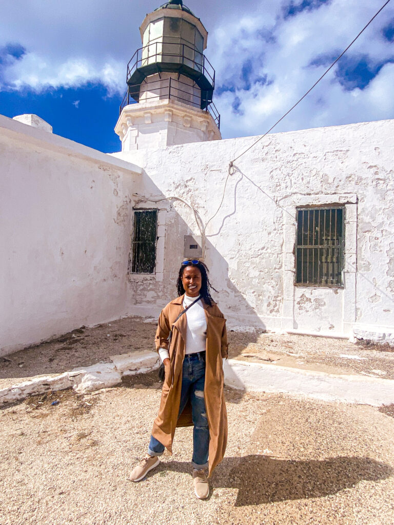 11 Signs You Need Your First Solo Trip - standing at a lighthouse in mykonos