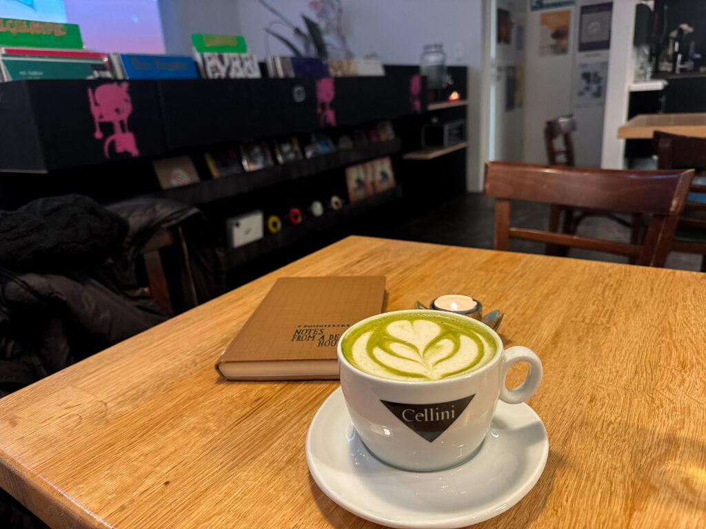 aesthetic matcha latte with book inside Smekkleysa Record Shop and Cafe 