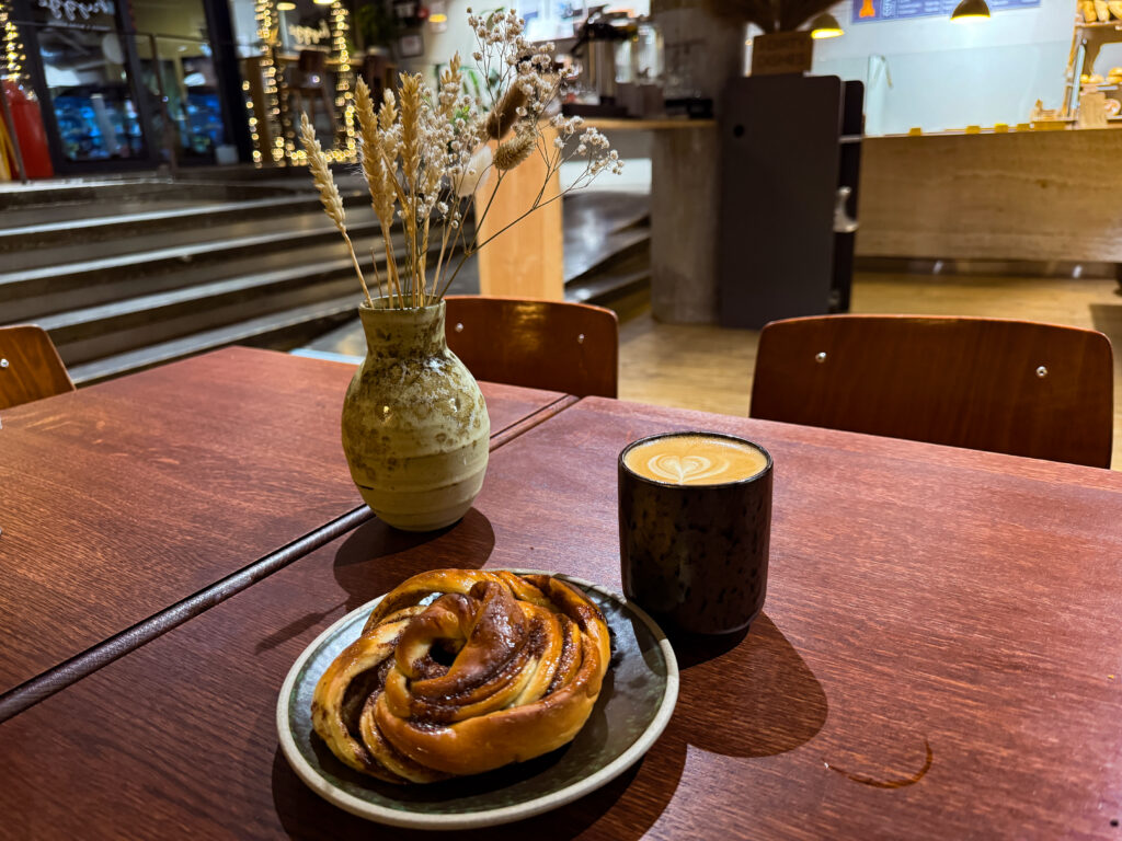 Solo traveler eating a cinnamon knot at Hygge Microbakery Reykjavik
