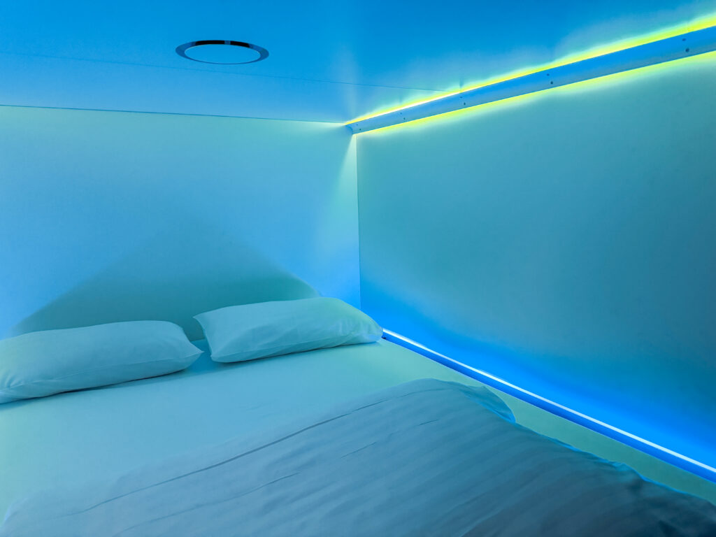 Modern purple-lit sleeping pods and social hangout area at CityHub hotel in Reykjavik Iceland.