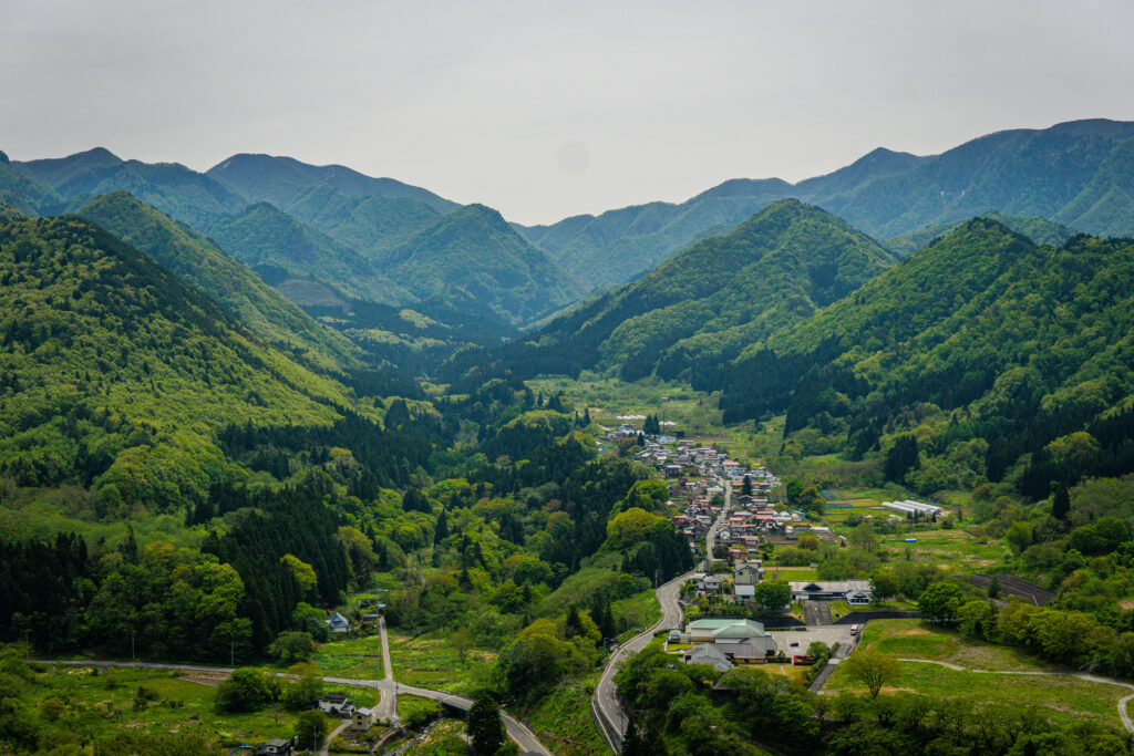 Panoramic view of the lush Yamagata mountain valley from the wooden Godaido observation deck at Yamadera