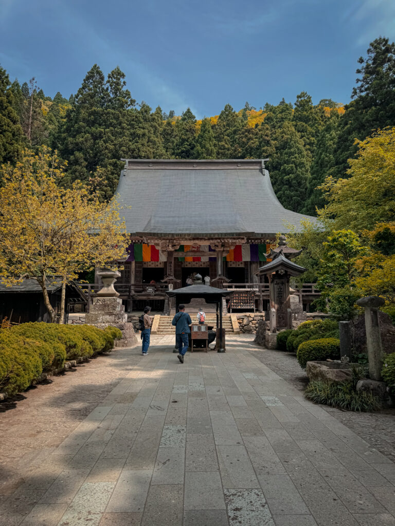 Exterior view of Konponchudo Main Hall at Yamadera Temple surrounded by vibrant green foliage