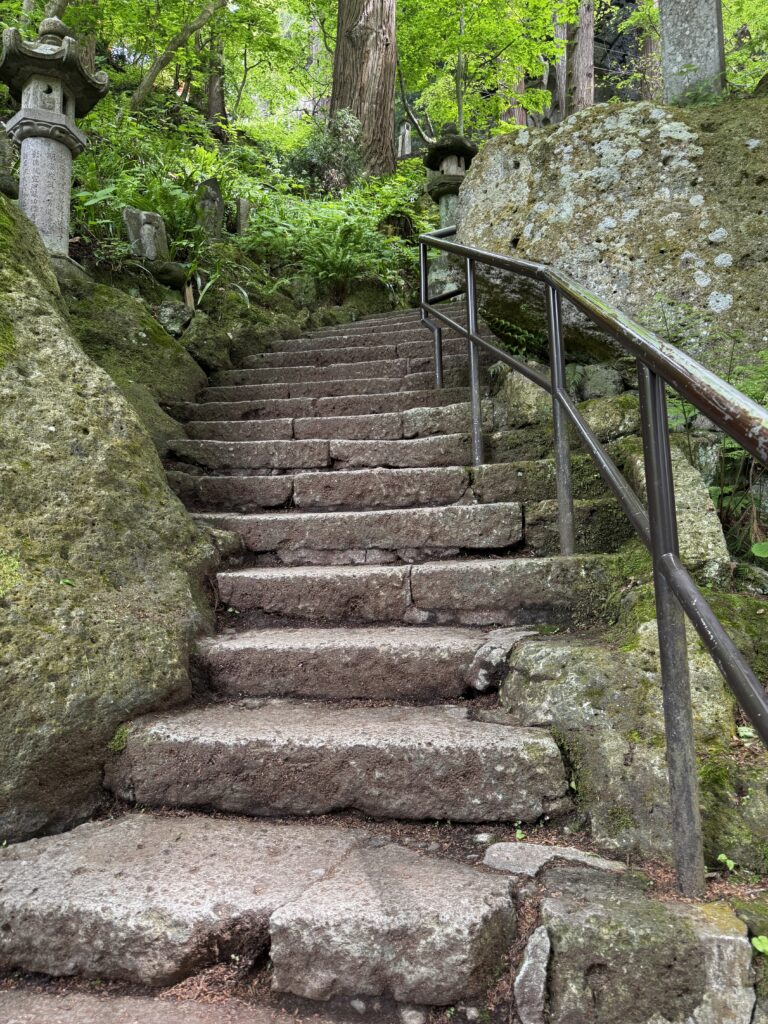 winding stairs through the forest at yamadera japan