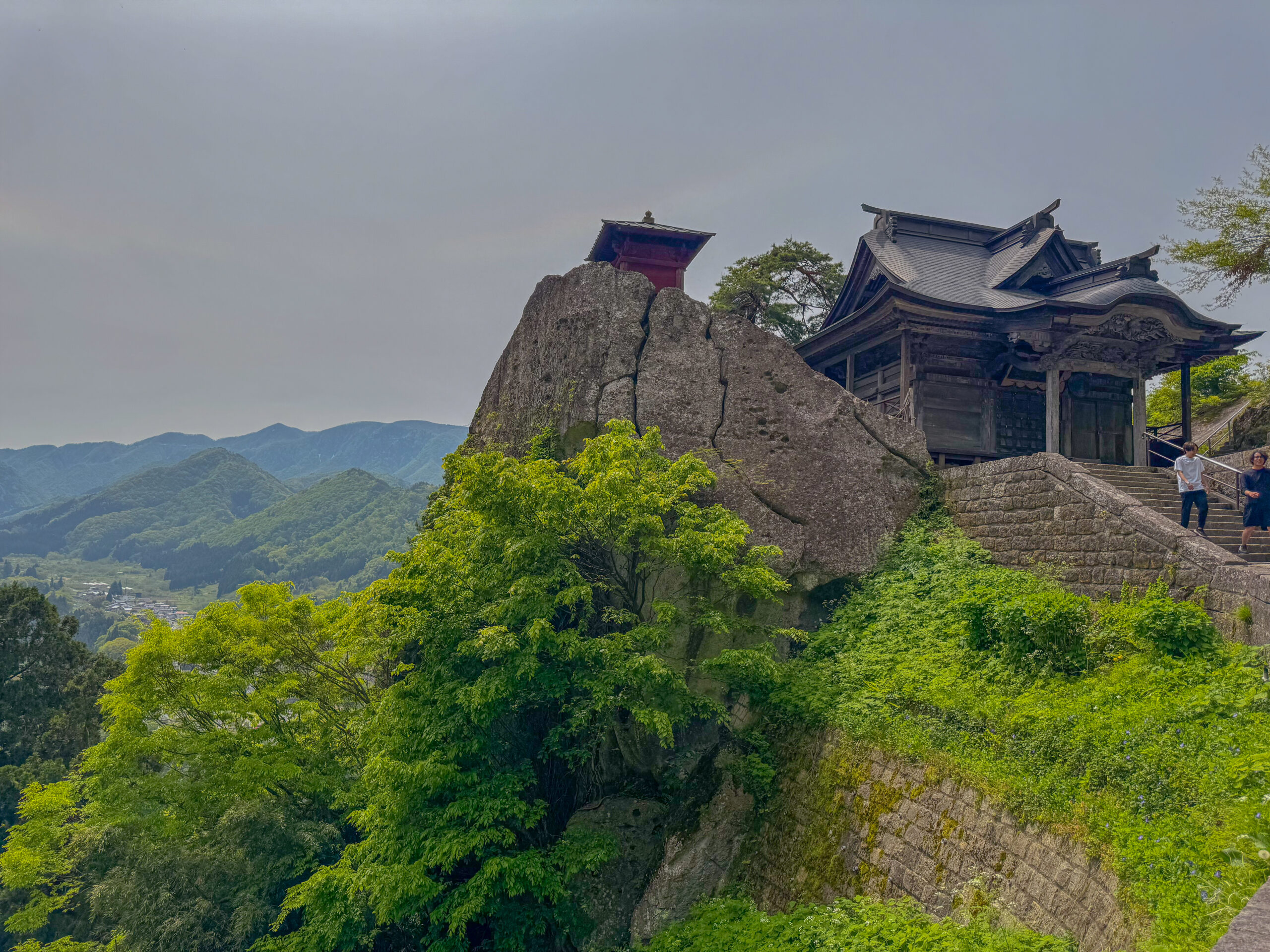 Historic red Nokyodo hall perched precariously on a rocky cliffside peak at Yamadera Temple yamadera day trip