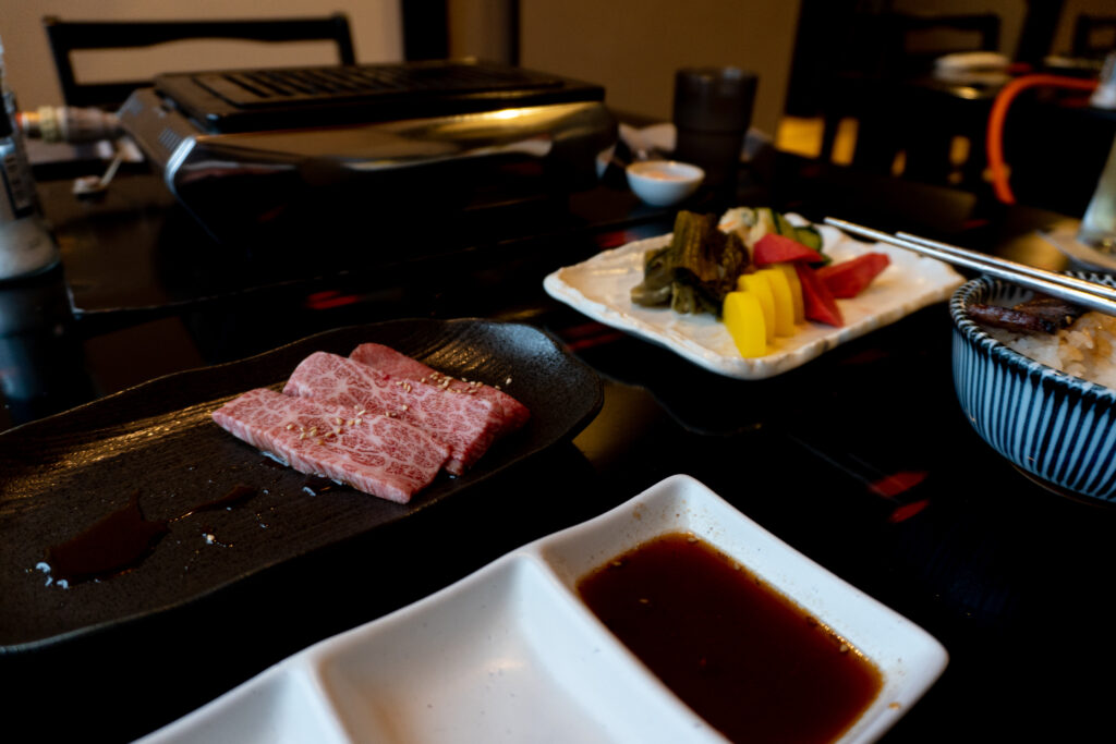 Close-up of cooked Yonezawa beef slices showing rich marbling and grill marks at Hachiman in Zao Onsen.